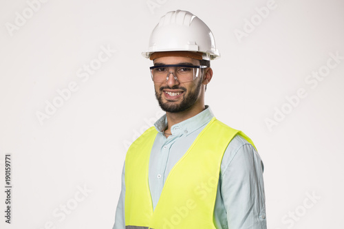 bearded handsome smiling engineer worker  l , wearing security helmet glasses and vest , isolated on white