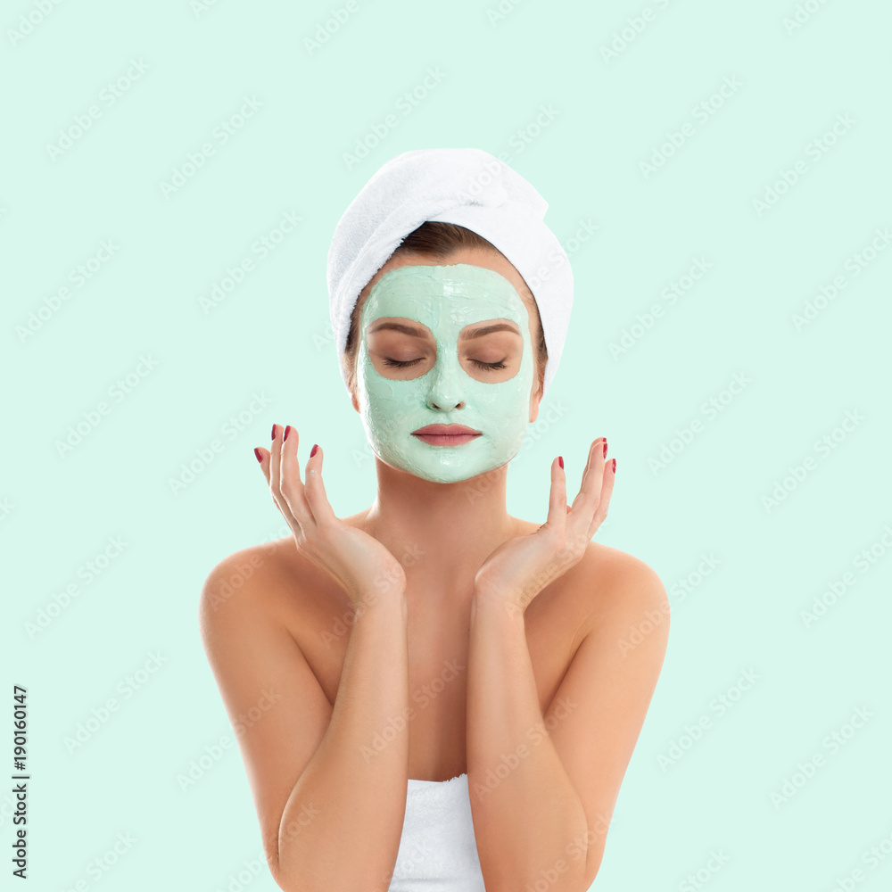 Φωτογραφία Woman is getting facial clay mask on pastel green background