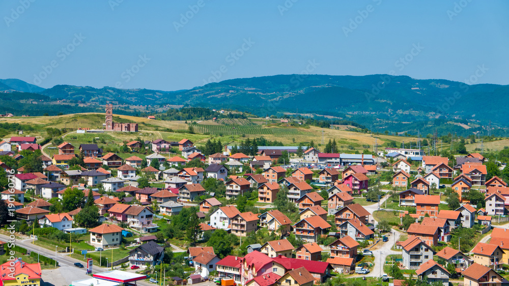 Residential buildings and houses in charming hilly landscape, aerial view