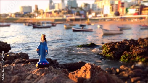 A small statue of Yemanja standing on the rocks at Rio Vermelho during a celebration in the honor of the Queen of the Sea in Salvador, Bahia, Brazil