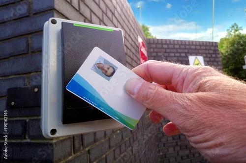 Green light on an electronic card reader, showing a man being allowed access to a secure location