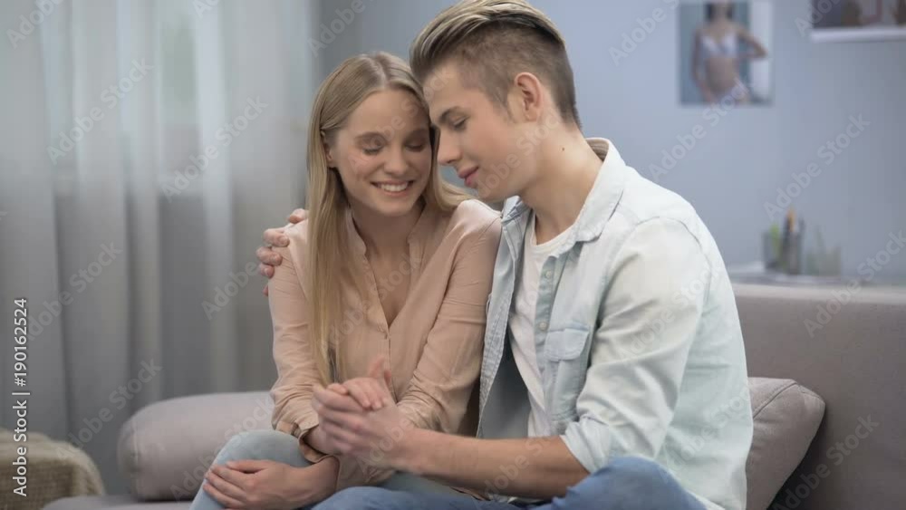 Loving couple of teenagers hugging and gently touching each other hands on date Loving couple of teenagers hugging and gently touching each other hands on date