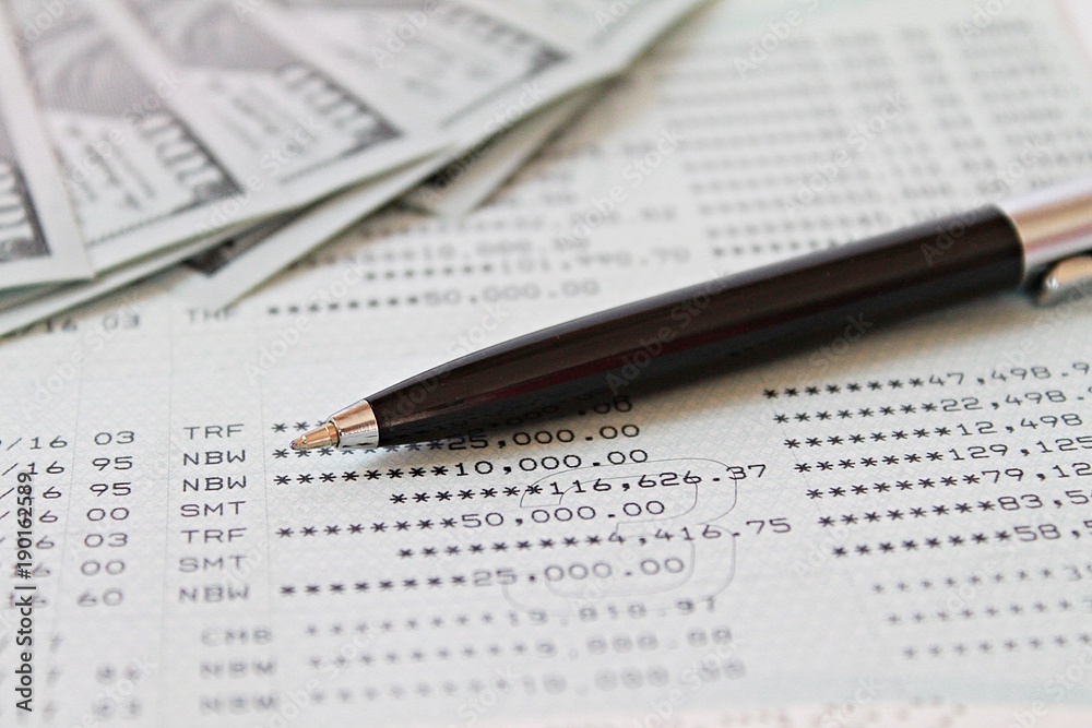 Business, finance, investment, accounting or money exchange concept : American Dollars cash money on savings account passbook or financial statement