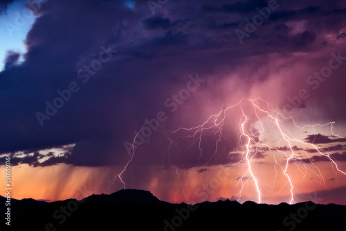 Lightning strikes from a monsoon thunderstorm at sunset in the Arizona desert