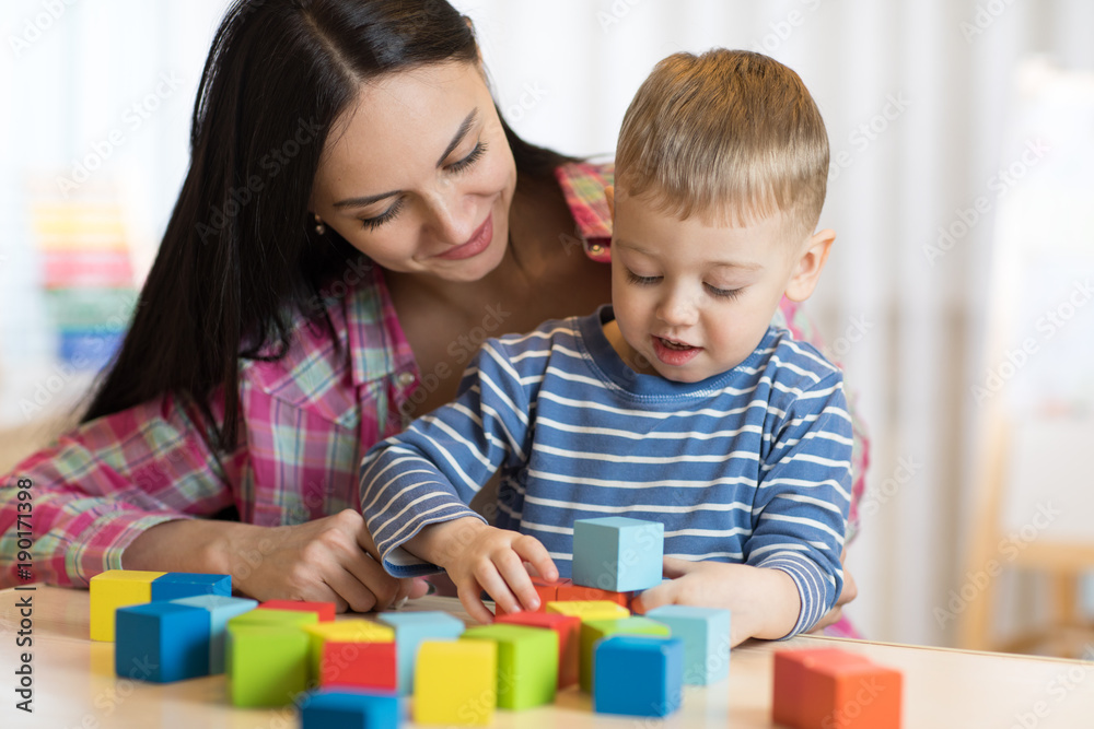 Child boy together with mother playing toys Child boy together with mother playing toys