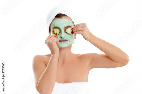 Beautiful woman with clay mask and cucumber on white background. Beauty and spa