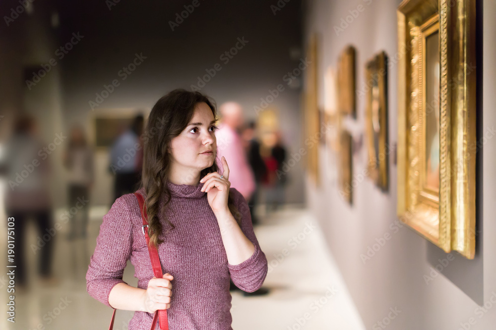 Young woman watching at art collection