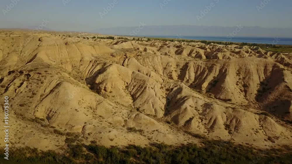Beautiful hills and lake Issyk-Kul in Kyrgyzstan by flying back drone Beautiful hills and lake Issyk-Kul in Kyrgyzstan by flying back drone