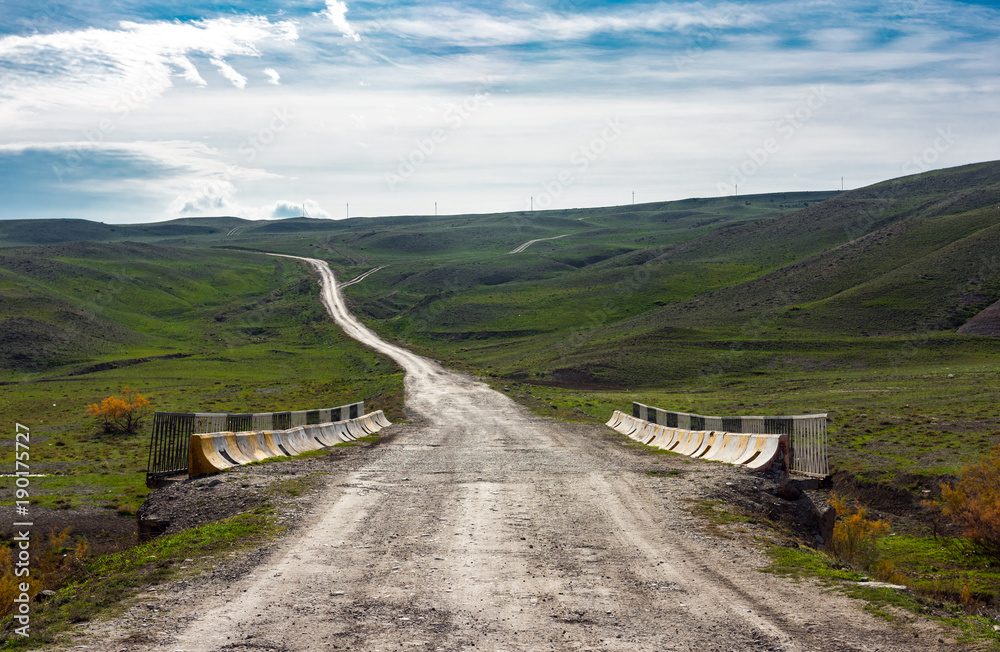 Fototapeta premium Road to mountains in the valley, mountain landscape