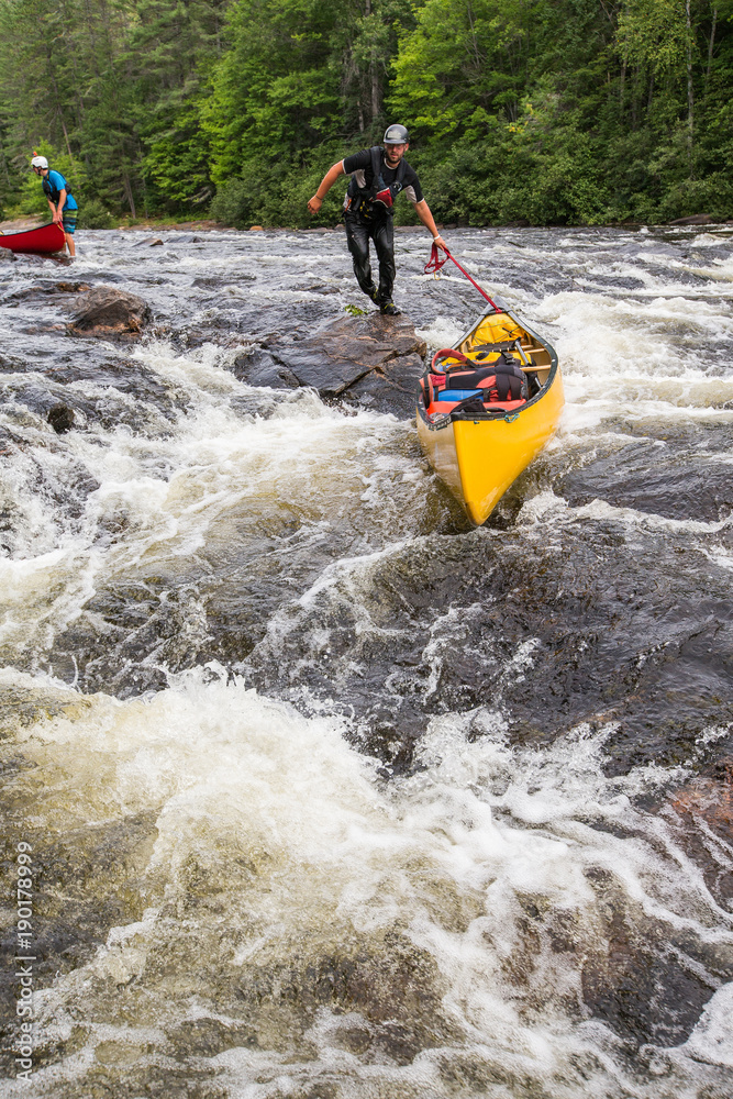 Portaging whitewater in canoes on the Noire River in Quebec, Canada.
