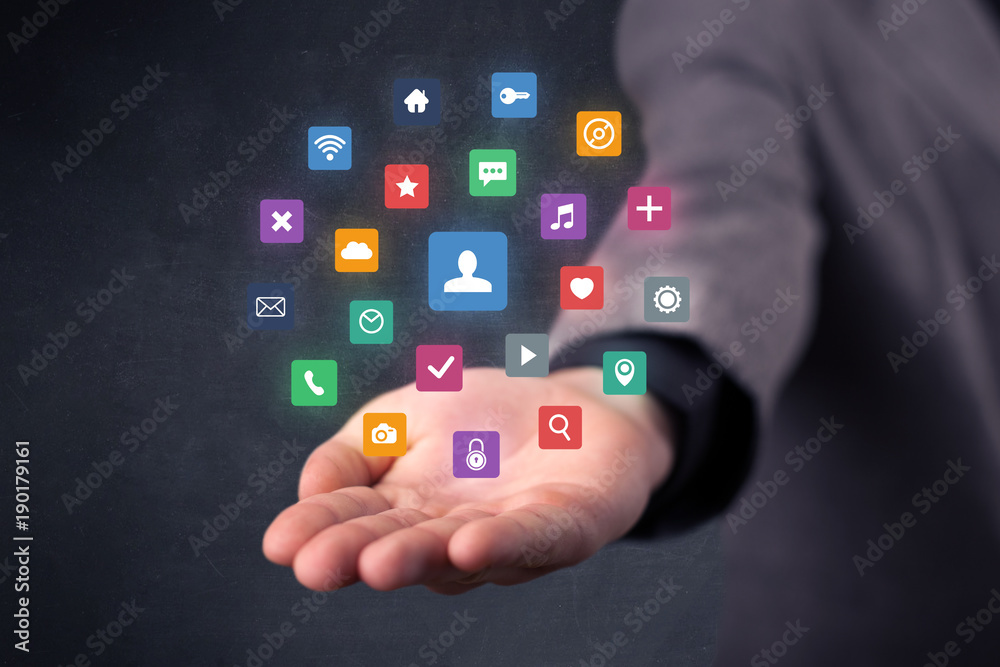 Businessman holding colorful applications Businessman holding colorful applications