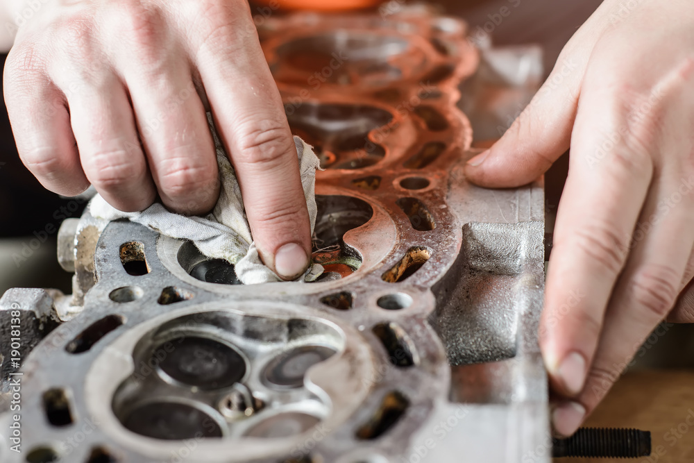 The mechanic restores the worn out car engine. grooving of cylinder