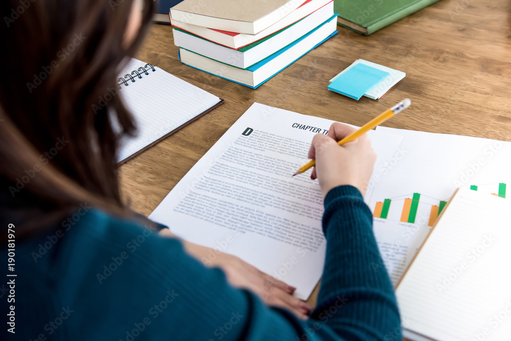Obraz premium Female college student reading information on paper, doing homework