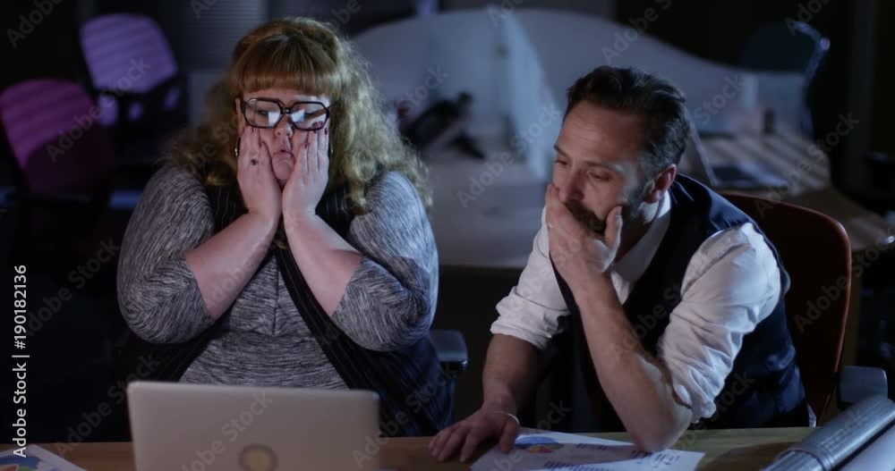 4K Business man & woman reacting very badly to something they see on computer. Funny business failure concept. Slow motion.