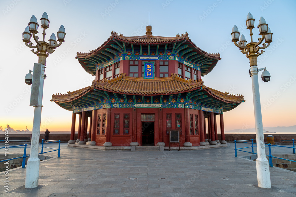 Obraz premium Molo Zhanqiao o wschodzie słońca, Qingdao, Shandong, Chiny. Nazwa „Huilan Pavilion” jest wygrawerowana nad drzwiami wejściowymi.