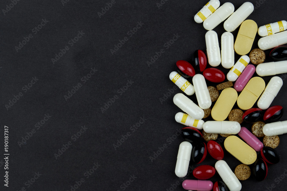 white and yellow pills, tablets, vitamins, medicine, pills and drugs scattered on a dark table. Pills for treatment and medicine. white and yellow pills, tablets, vitamins, medicine, pills and drugs scattered on a dark table. Pills for treatment and medicine.