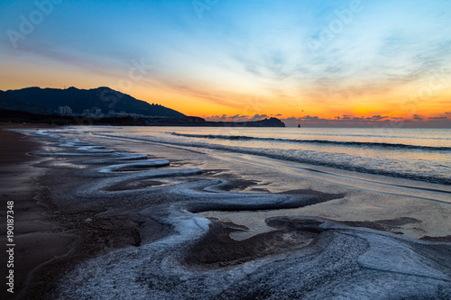 24th Jan 2018, Qingdao, Shandong. Sunrise on Shilaoren Beach, in a morning so cold that the water from the sea is turned into ice photo