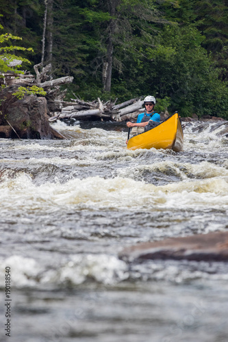 Canoeist stuck in a hole on the rapids of the Noire River, Quebec, Canada. © Colin