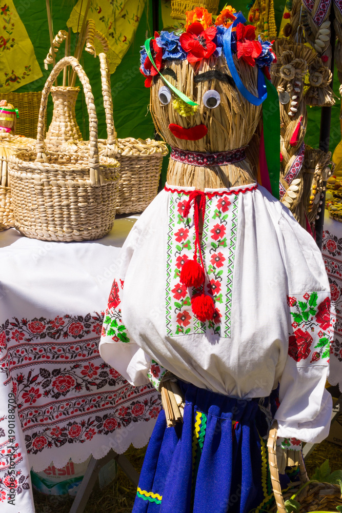 Straw dummy in traditional ukrainian clothing for decor during fair