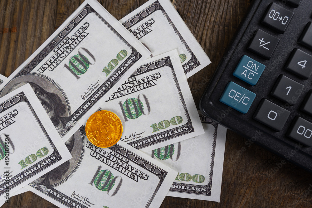 Fototapeta premium Banknotes, coins calculator on the wood table