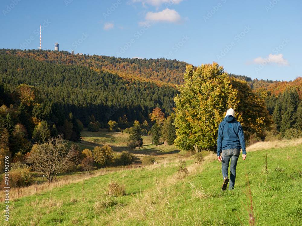Wanderer läuft  im Herbst im Mittelgebirge mit Inselberg