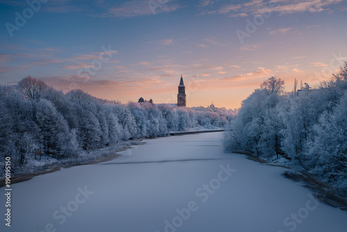 Beautiful landscape view of Aura river with Turku Cathedral and the old observatory building on Vartiovuori hill in the background in Turku, Finland - January 2018 photo