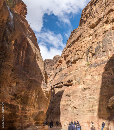 Panoramic view of tourists walking in Petra gorge at cold winter day