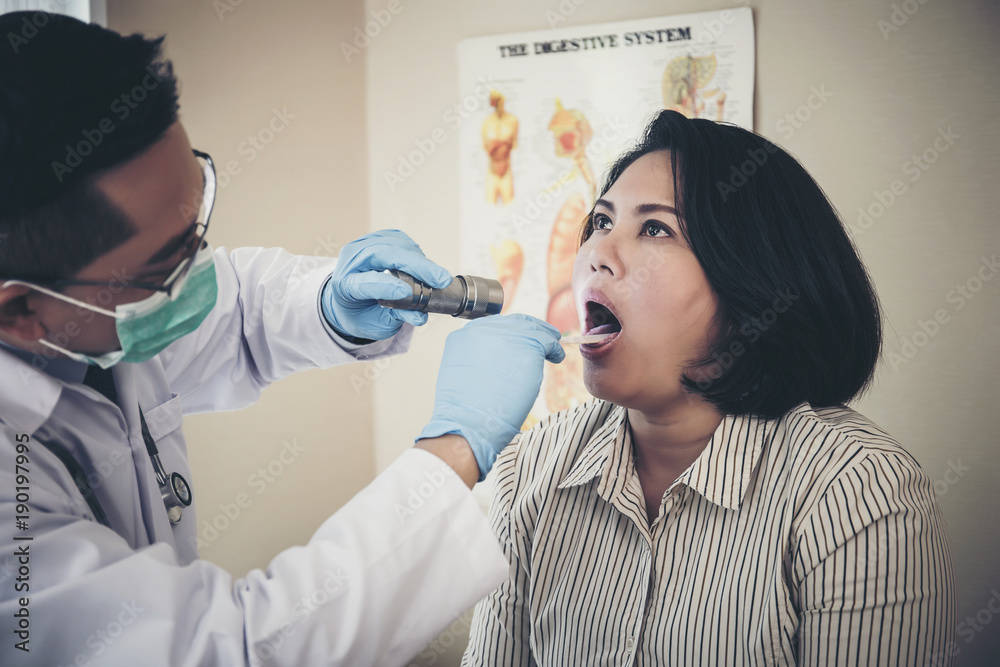 doctor in white uniform gown checkup patient's mouth with flashlight: Physician check up. doctor in white uniform gown checkup patient's mouth with flashlight: Physician check up.