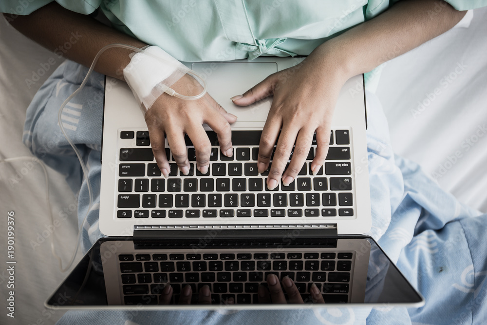 Close up of Sick woman works with laptop in hospital.