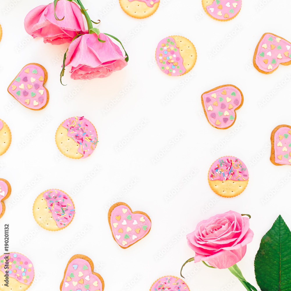 Cookies with pink glaze and roses on white background. Love composition. Flat lay. top view. Cookies with pink glaze and roses on white background. Love composition. Flat lay. top view.