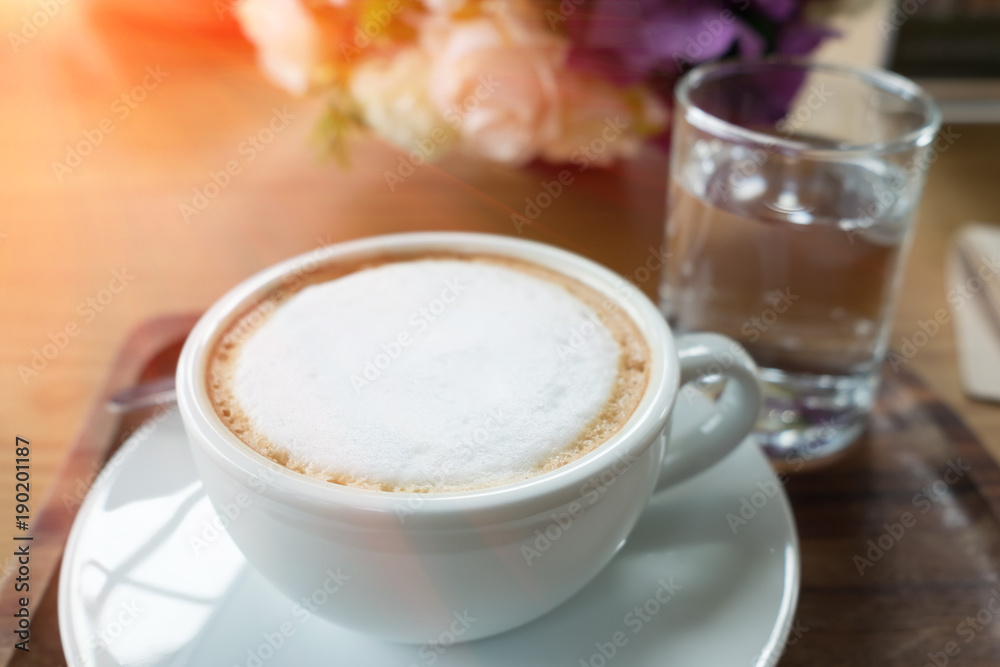 Coffee in white cup served with morning water. Coffee in white cup served with morning water.