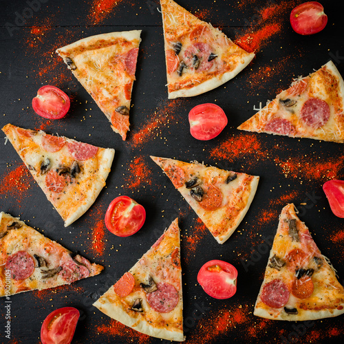 Italian pizza with ingredients. Flat lay, top view. Pizza chips pattern on dark table