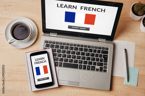 Learn French concept on laptop and smartphone screen over wooden table. All screen content is designed by me. Flat lay