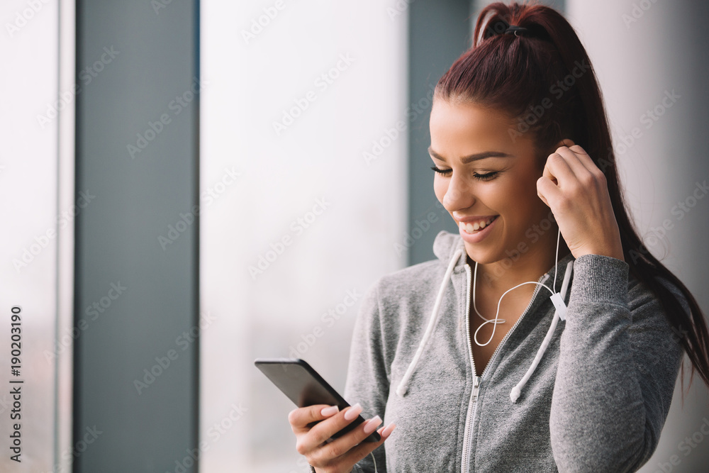 Young fitness woman using phone after running indoors. Young fitness woman using phone after running indoors.