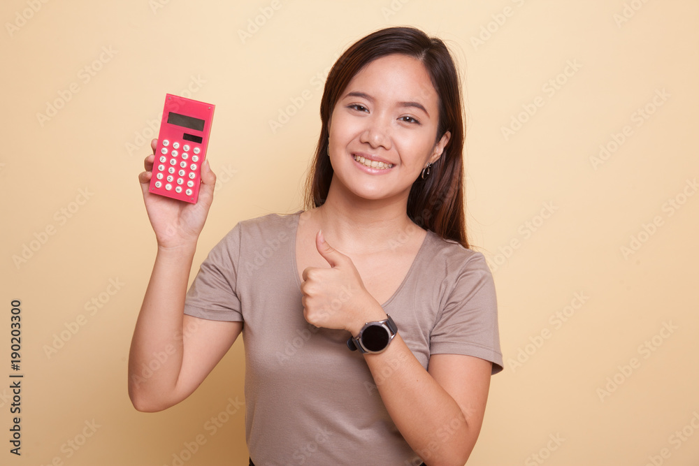 Asian woman thumbs up with calculator. Asian woman thumbs up with calculator.