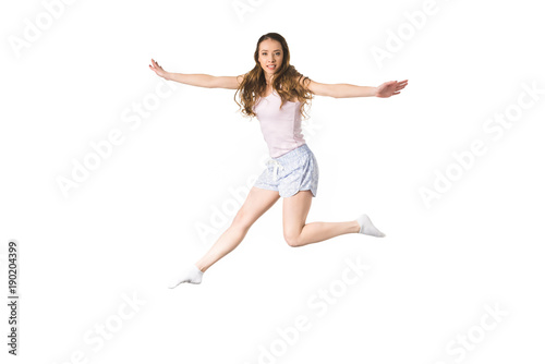 beautiful happy girl jumping and smiling at camera isolated on white