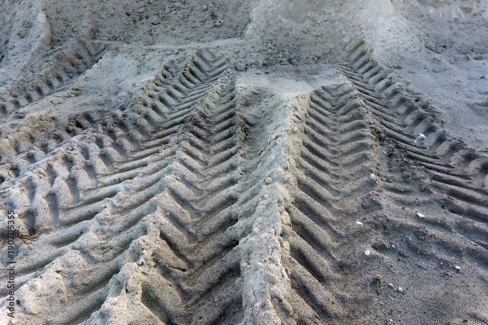 traces of soft sand from a heavy tractor that has passed, close-up, autumn, on the adneg plan shines and glare of the sun . traces of soft sand from a heavy tractor that has passed, close-up, autumn, on the adneg plan shines and glare of the sun .