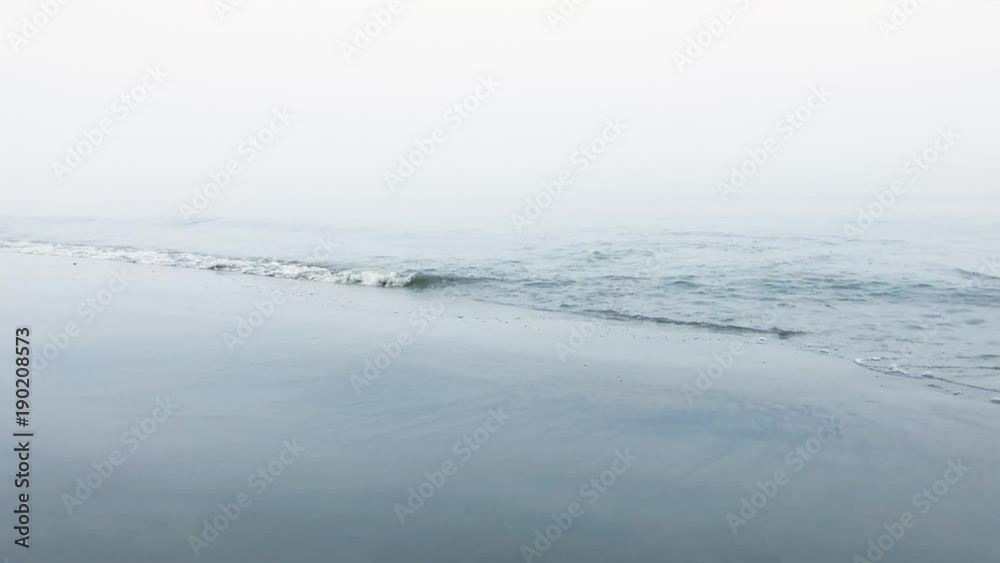 waves rolling onto beach of Elbe river on misty morning waves rolling onto beach of Elbe river on misty morning