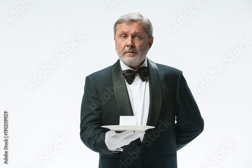 Senior waiter holding tray
