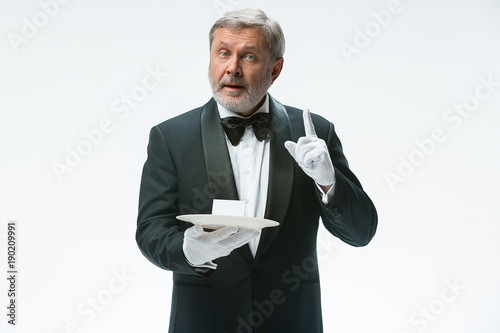 Senior waiter holding tray