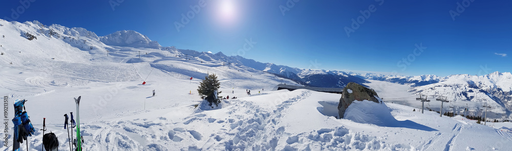 ski slopes in mountain panorama under blue sky  in winter