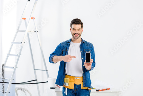 man pointing on smartphone and looking at camera