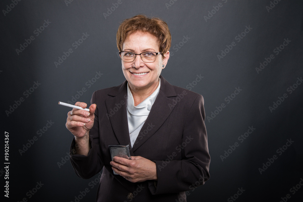 Business senior lady holding cigarrete and box Business senior lady holding cigarrete and box