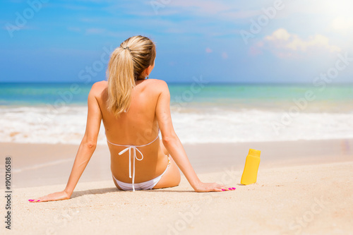 Woman with UV protection cream bottle on the beach © Kaspars Grinvalds