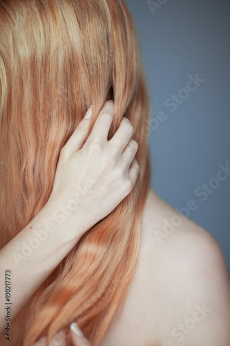 Close up woman hands maintain, comb her hair, sensual look studio portrait beauty