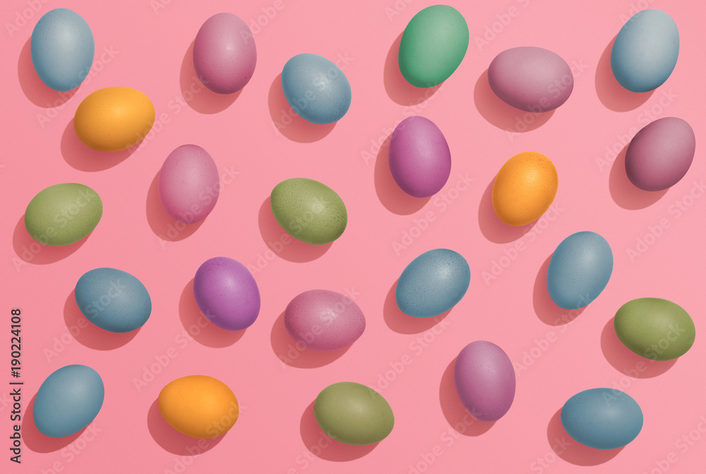 Multi colored Easter eggs on pink background, fun Easter flat lay Multi colored Easter eggs on pink background, fun Easter flat lay