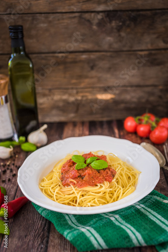 Spaghetti pasta with tomato sauce  and fresh basil - homemade healthy italian pasta on rustic wooden background