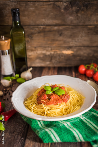 Spaghetti pasta with tomato sauce and fresh basil - homemade healthy italian pasta on rustic wooden background
