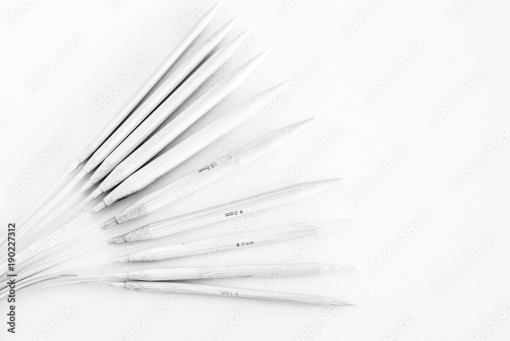 various sizes of bamboo rounded knitting needles. black and white photo