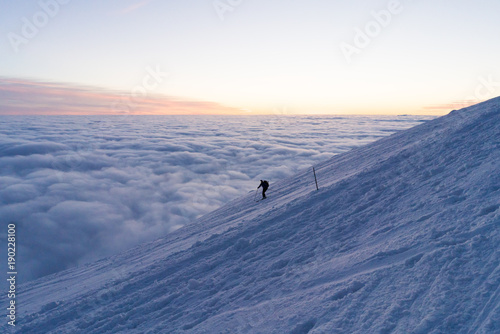 Skiing on snow in Slovak mountains above clouds during sunset in winter